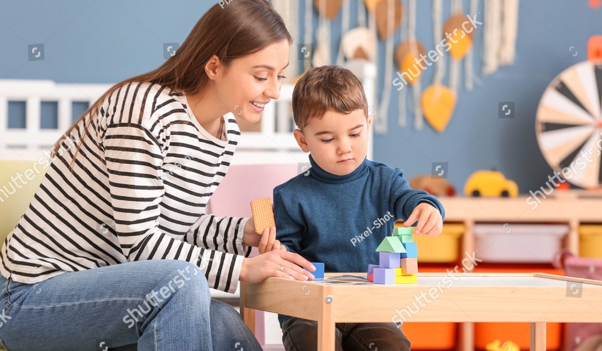 Garde d'enfant qui joue avec un petit garçon à la maison