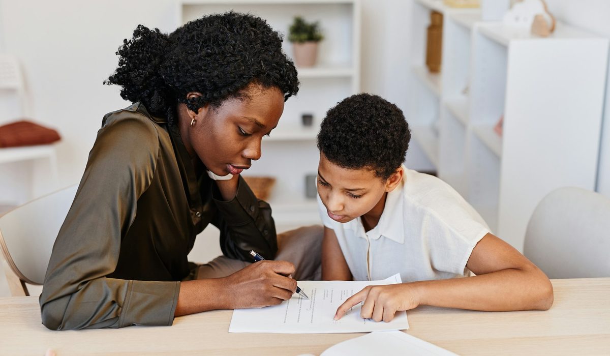 Étudiante qui donne un cours de soutien scolaire à un collégien
