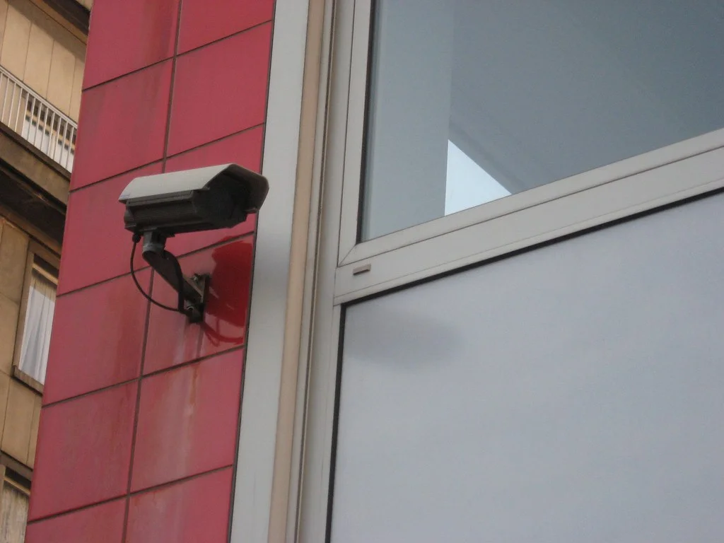 Caméra de surveillance fixée sur une façade d'immeuble