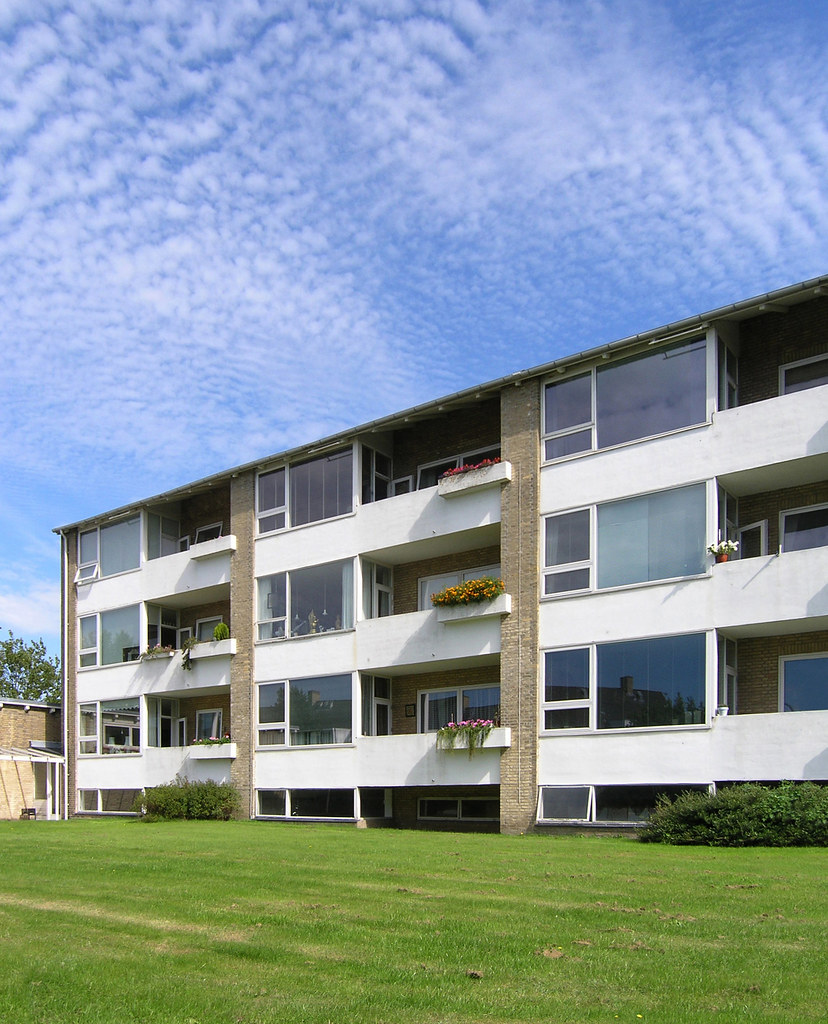 Immeuble résidentiel avec balcons fleuris et pelouse